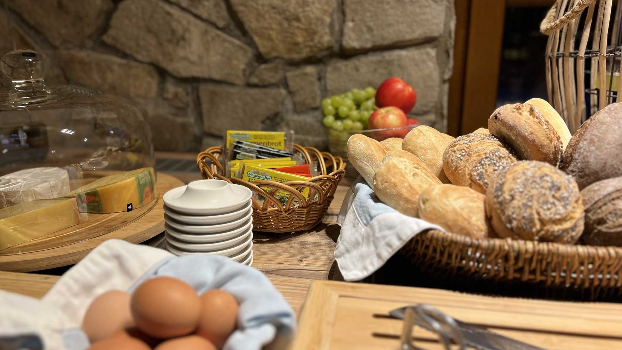 Frisches Frühstücksbuffet im Hotel Aal-Kate mit Brötchenauswahl, gekochten Eiern, Käse, Aufstrichen und frischem Obst.