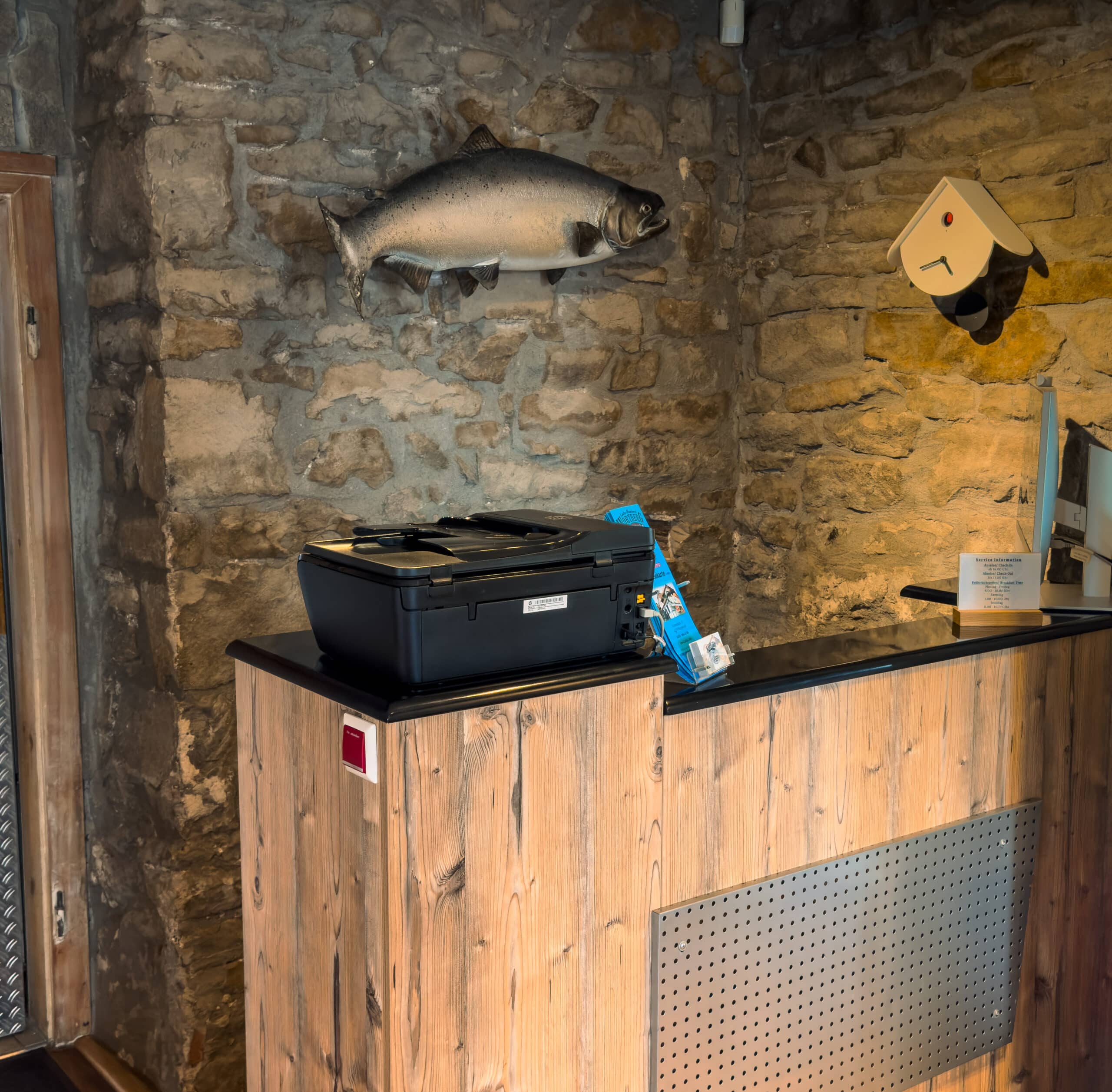 Empfangstresen im Hotel in der Aal-Kate mit Fischdeko an der Steinwand